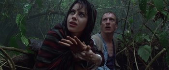Movie still from “The Island of Dr. Moreau” (1996), directed by Richard Stanley – A man and a woman in the woods looking at the camera; Close Up shot, Low angle
