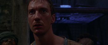 Movie still from “The Island of Dr. Moreau” (1996), directed by Richard Stanley – A person looking at the camera; Close Up shot, Low angle