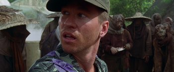 Movie still from “The Island of Dr. Moreau” (1996), directed by Richard Stanley – A person wearing a hat; Close Up shot, Over the shoulder angle