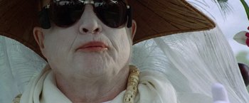 Movie still from “The Island of Dr. Moreau” (1996), directed by Richard Stanley – A person wearing sunglasses and a hat; Extreme Close Up shot, Low angle