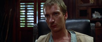 Movie still from “The Island of Dr. Moreau” (1996), directed by Richard Stanley – A person sitting in a chair; Close Up shot, Low angle