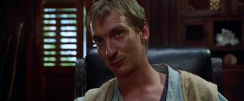 Movie still from “The Island of Dr. Moreau” (1996), directed by Richard Stanley – A person sitting in a chair; Close Up shot, Low angle