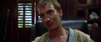 Movie still from “The Island of Dr. Moreau” (1996), directed by Richard Stanley – A person sitting in a chair; Close Up shot, Low angle