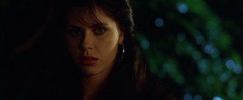 Movie still from “The Island of Dr. Moreau” (1996), directed by Richard Stanley – A person with long dark hair; Close Up shot, Over the shoulder angle