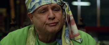 Movie still from “The Island of Dr. Moreau” (1996), directed by Richard Stanley – An older man wearing a head scarf and a green shirt; Close Up shot, Low angle