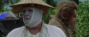 Movie still from “The Island of Dr. Moreau” (1996), directed by Richard Stanley – A man in a straw hat and a white shirt; Close Up shot, Over the shoulder angle