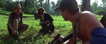 Movie still from “The Island of Dr. Moreau” (1996), directed by Richard Stanley – A man in a suit and a man with a gun; Medium shot, Low angle