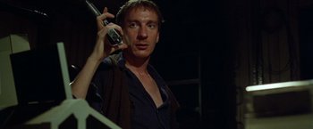 Movie still from “The Island of Dr. Moreau” (1996), directed by Richard Stanley – A man holding a cell phone up to his ear; Close Up shot, Low angle