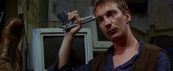 Movie still from “The Island of Dr. Moreau” (1996), directed by Richard Stanley – A man holding a cell phone up to his ear; Close Up shot, Low angle
