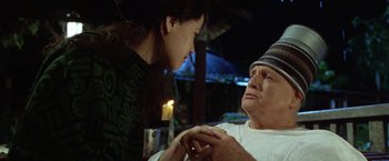 Movie still from “The Island of Dr. Moreau” (1996), directed by Richard Stanley – An older man and a younger woman holding hands; Close Up shot, Over the shoulder angle