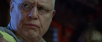 Movie still from “The Island of Dr. Moreau” (1996), directed by Richard Stanley – An older man with glasses is looking at the camera; Close Up shot, Low angle
