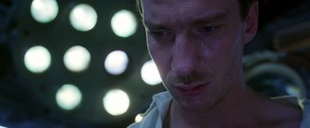 Movie still from “The Island of Dr. Moreau” (1996), directed by Richard Stanley – A man's face in a dark room; Close Up shot, Low angle