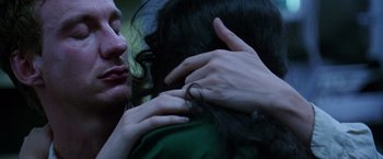 Movie still from “The Island of Dr. Moreau” (1996), directed by Richard Stanley – A man and a woman embracing each other; Close Up shot, Over the shoulder angle