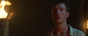 Movie still from “The Island of Dr. Moreau” (1996), directed by Richard Stanley – A person wearing headphones in a dark room; Close Up shot, Low angle