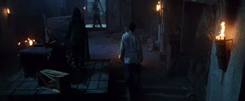 Movie still from “The Island of Dr. Moreau” (1996), directed by Richard Stanley – A man walking down a street at night; Wide shot, High angle