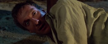 Movie still from “The Island of Dr. Moreau” (1996), directed by Richard Stanley – A person laying on the ground; Close Up shot, High angle