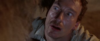 Movie still from “The Island of Dr. Moreau” (1996), directed by Richard Stanley – A man's face in a dark room; Close Up shot, Overhead angle
