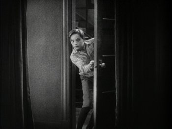 Movie still from “The Jazz Singer” (1927), directed by Alan Crosland – A young man standing in front of an open door; Medium shot, High angle