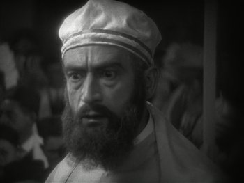 Movie still from “The Jazz Singer” (1927), directed by Alan Crosland – A man with a beard wearing a hat; Close Up shot, High angle