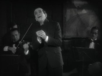 Movie still from “The Jazz Singer” (1927), directed by Alan Crosland – An old man in a black suit is singing; Medium shot, Low angle