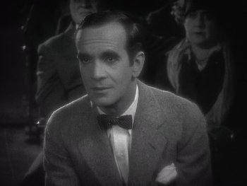 Movie still from “The Jazz Singer” (1927), directed by Alan Crosland – A man wearing a suit and a bow tie; Close Up shot, High angle