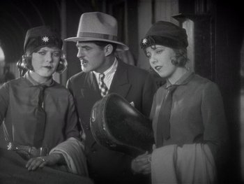 Movie still from “The Jazz Singer” (1927), directed by Alan Crosland – A man and two women wearing hats and suits; Medium shot, Low angle