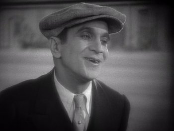 Movie still from “The Jazz Singer” (1927), directed by Alan Crosland – An old photo of a man wearing a hat and a suit; Close Up shot, High angle