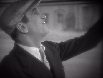 Movie still from “The Jazz Singer” (1927), directed by Alan Crosland – A man wearing a suit and a hat is looking up at the sky; Close Up shot, High angle