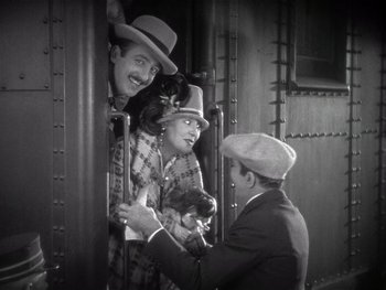 Movie still from “The Jazz Singer” (1927), directed by Alan Crosland – A black - and - white photo of a man holding a cat; Medium shot, High angle