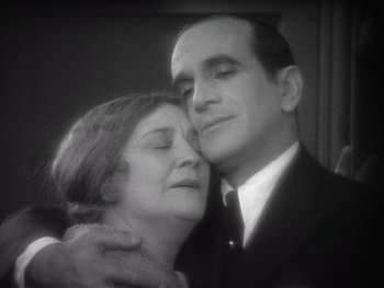 Movie still from “The Jazz Singer” (1927), directed by Alan Crosland – An older man and a younger woman embracing; Close Up shot, High angle