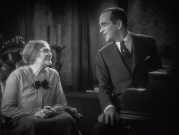 Movie still from “The Jazz Singer” (1927), directed by Alan Crosland – An older man and a younger woman sitting next to each other; Medium shot, High angle