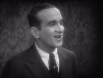 Movie still from “The Jazz Singer” (1927), directed by Alan Crosland – An old photo of a man in a suit; Close Up shot, High angle