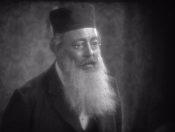 Movie still from “The Jazz Singer” (1927), directed by Alan Crosland – An old man with a long beard wearing a hat; Close Up shot, Low angle