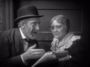 Movie still from “The Jazz Singer” (1927), directed by Alan Crosland – An older man and woman are talking to each other; Close Up shot, High angle