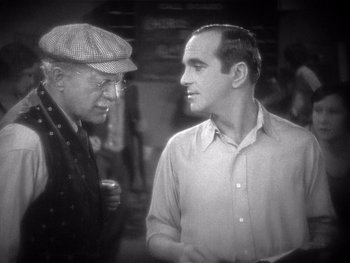 Movie still from “The Jazz Singer” (1927), directed by Alan Crosland – Two men are talking to each other in a black and white photo; Close Up shot, Over the shoulder angle