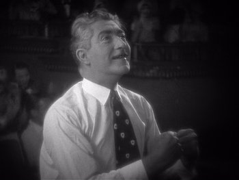 Movie still from “The Jazz Singer” (1927), directed by Alan Crosland – An older man wearing a neck tie and a white shirt; Close Up shot, Low angle