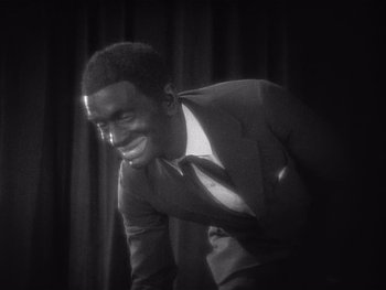Movie still from “The Jazz Singer” (1927), directed by Alan Crosland – A black and white photo of a man in a suit; Close Up shot, High angle