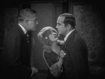 Movie still from “The Jazz Singer” (1927), directed by Alan Crosland – A man and a woman kiss on the cheek of another man; Medium shot, High angle