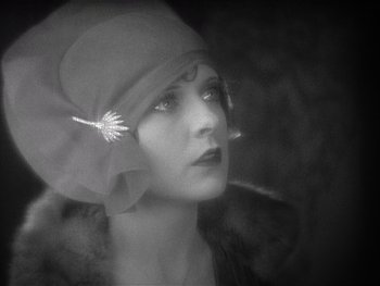 Movie still from “The Jazz Singer” (1927), directed by Alan Crosland – A woman wearing a hat with a feather in her hair; Close Up shot, Low angle