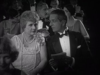 Movie still from “The Jazz Singer” (1927), directed by Alan Crosland – An older woman and a young man in formal wear; Medium shot, High angle