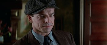 Movie still from “The Journey of Natty Gann” (1985), directed by Jeremy Kagan – A person wearing a suit and hat; Close Up shot, Over the shoulder angle