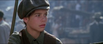 Movie still from “The Journey of Natty Gann” (1985), directed by Jeremy Kagan – A young boy wearing a hat and a uniform; Close Up shot, Low angle