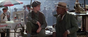 Movie still from “The Journey of Natty Gann” (1985), directed by Jeremy Kagan – A young boy sitting next to an older man; Medium shot, Over the shoulder angle