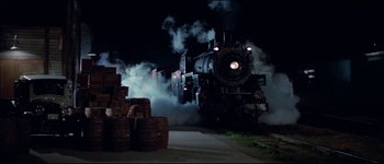 Movie still from “The Journey of Natty Gann” (1985), directed by Jeremy Kagan – A steam train is coming down the tracks at night; Extreme Wide shot, Low angle