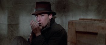 Movie still from “The Journey of Natty Gann” (1985), directed by Jeremy Kagan – A man in a hat is smoking a cigarette; Close Up shot, Low angle