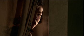 Movie still from “The Journey of Natty Gann” (1985), directed by Jeremy Kagan – A woman looking out a window at the camera; Close Up shot, Low angle
