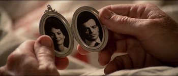 Movie still from “The Journey of Natty Gann” (1985), directed by Jeremy Kagan – A man and a woman are holding a picture of a man and a woman; Extreme Close Up shot, Overhead angle