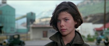 Movie still from “The Journey of Natty Gann” (1985), directed by Jeremy Kagan – A young woman with blue eyes looking into the distance; Close Up shot, Over the shoulder angle