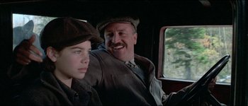 Movie still from “The Journey of Natty Gann” (1985), directed by Jeremy Kagan – A man and a boy sitting in the back of a truck; Close Up shot, Over the shoulder angle