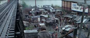 Movie still from “The Journey of Natty Gann” (1985), directed by Jeremy Kagan – A group of people standing around a lot of buildings; Extreme Wide shot, High angle